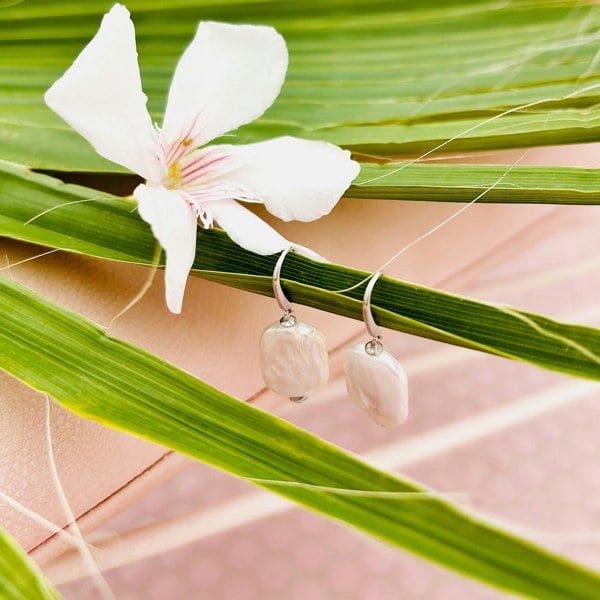 Pearl drop earrings with a flower and a palm leaf.
