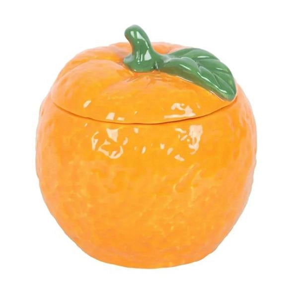 Orange-shaped candle jar with domed top and green leaf ornament, unlit
