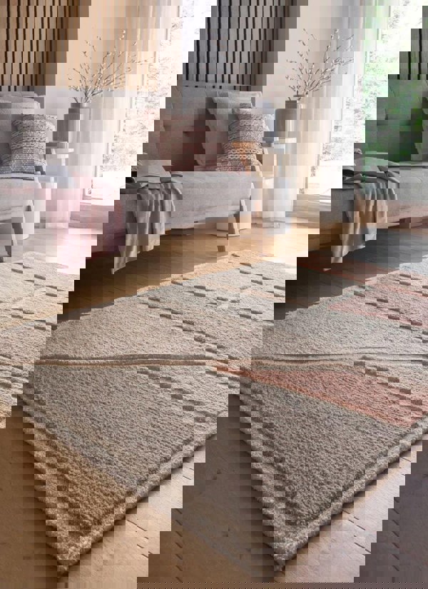 Strata Abstract Rug in soft pink and grey on a wood floor, enhancing modern home decor with texture and style.