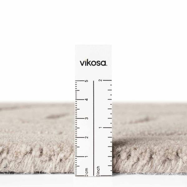 Rug with a ruler for scale on a white background, featuring the brand 'vikosa'.