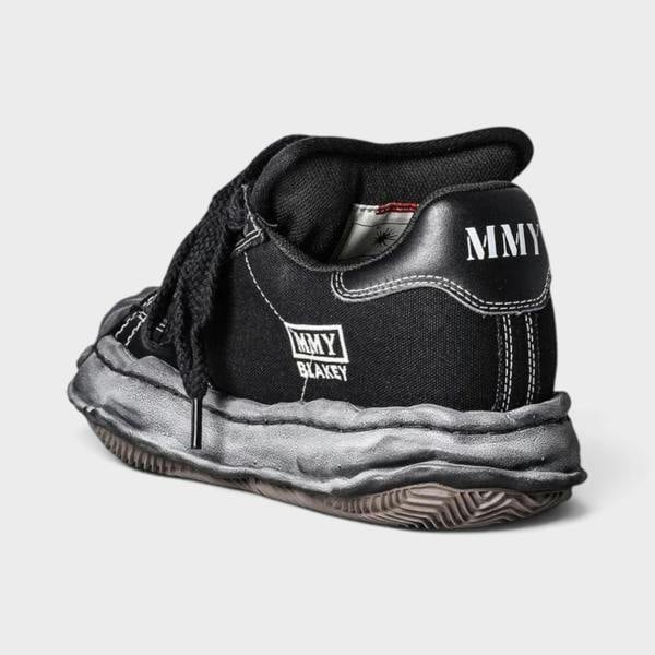Supplied Fashion Yasuhiro Blakey black canvas low-top sneaker with signature distressed OG sole and MMY heel branding.