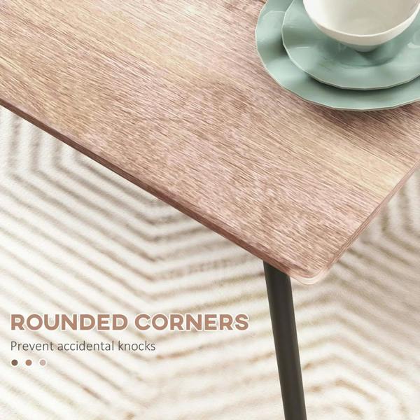 Wood-look dining table corner with rounded edges on black metal leg; close-up detail
