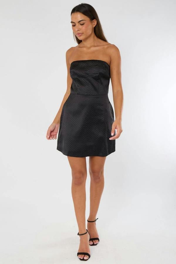 Woman wearing a black strapless dress on a white background