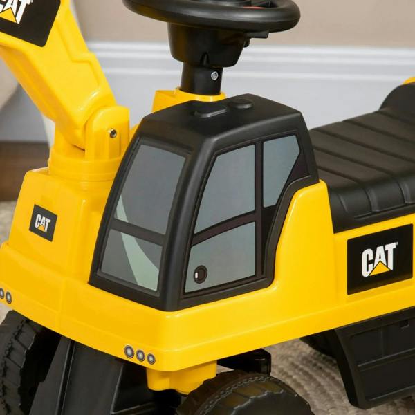 Yellow CAT ride-on digger dashboard with black steering wheel and window panel, close-up
