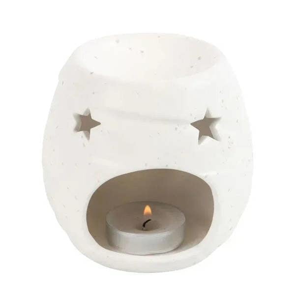 White ceramic mummy-shaped oil burner with star cutouts and visible candle flame inside