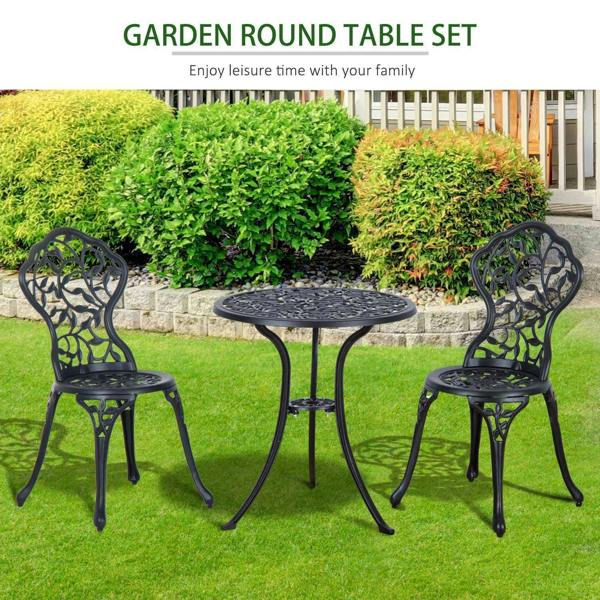 Black outdoor bistro dining set: round table and two ornate chairs on a lawn