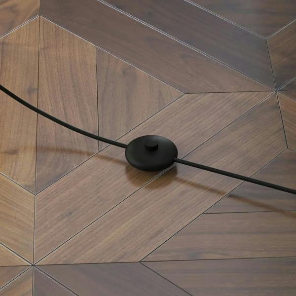 Brown floor lamp power cord near black round base on wooden floor