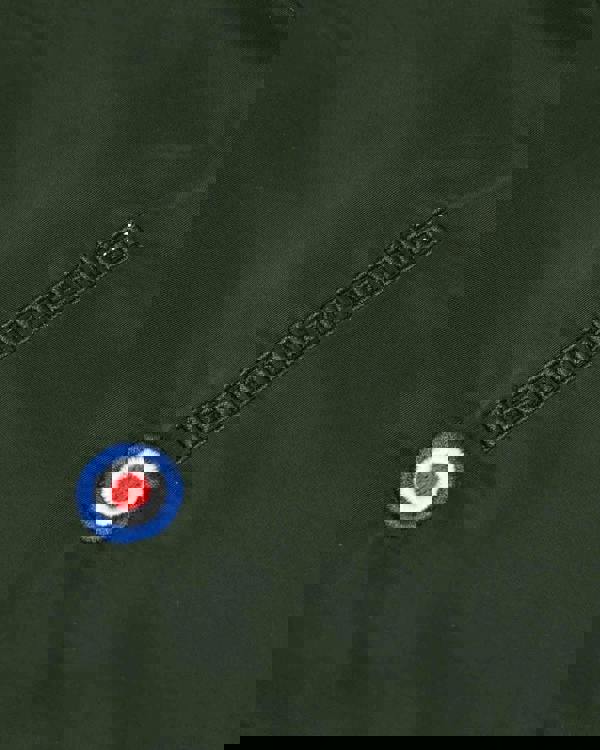 Lambretta Heaton Mens Shower-Resistant Mod Ska Hooded Lightweight Jacket Coat, close-up of the jacket's green fabric with embroidered Lambretta logo and target emblem patch.