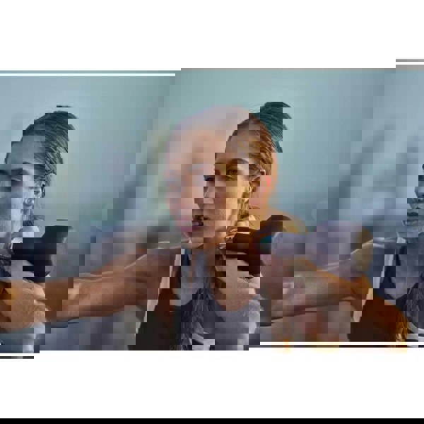 Woman exercising with an adidas 4kg kettlebell