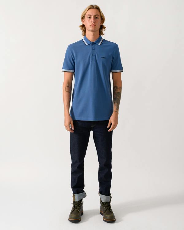 a full length studio photograph of a model wearing a BOSS Green Paddy Mens Cotton-Piqué Polo Shirt with Contrast Logo in Medium Blue 428
