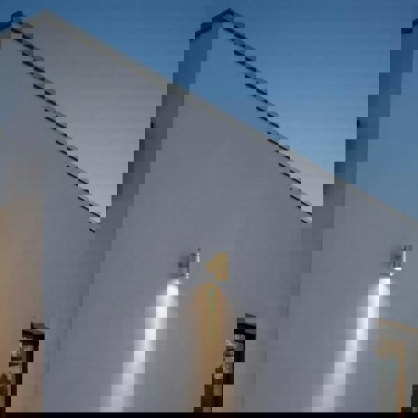 exterior brass wall light mounted on the exterior white wall of a modern home 