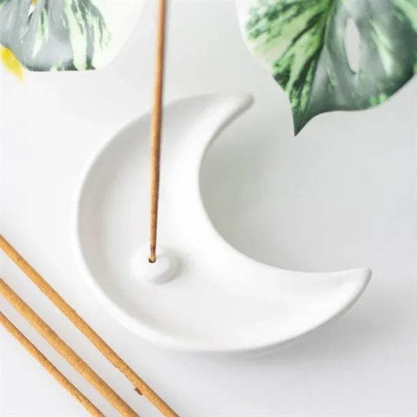 White crescent moon incense holder holding two incense sticks