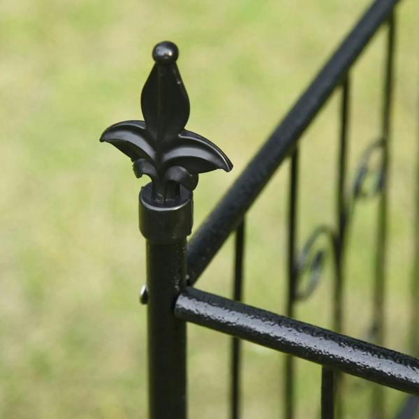 Black metal finial detail on the garden arbor frame, close-up view