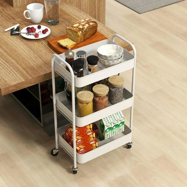 White three-tier storage trolley with casters, holding kitchen jars, cans, and utensils