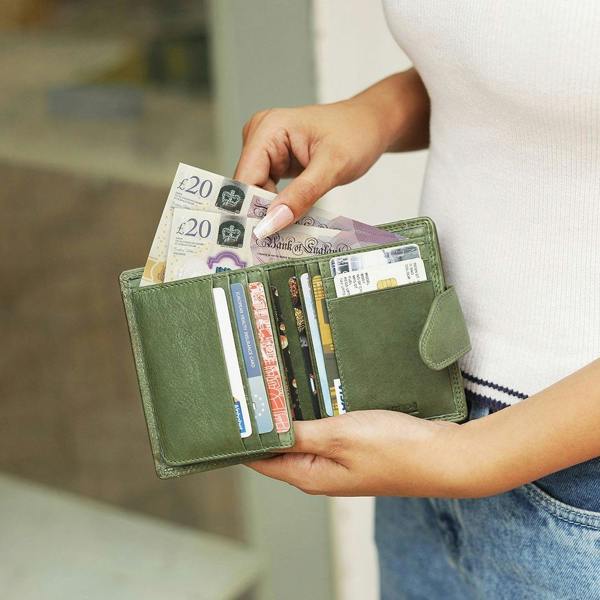 Green Paloma medium trifold purse in washed Cancun leather held in hand