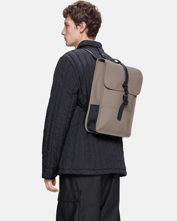 model carrying a Rains Unisex Backpack Mini in 173 Cinder