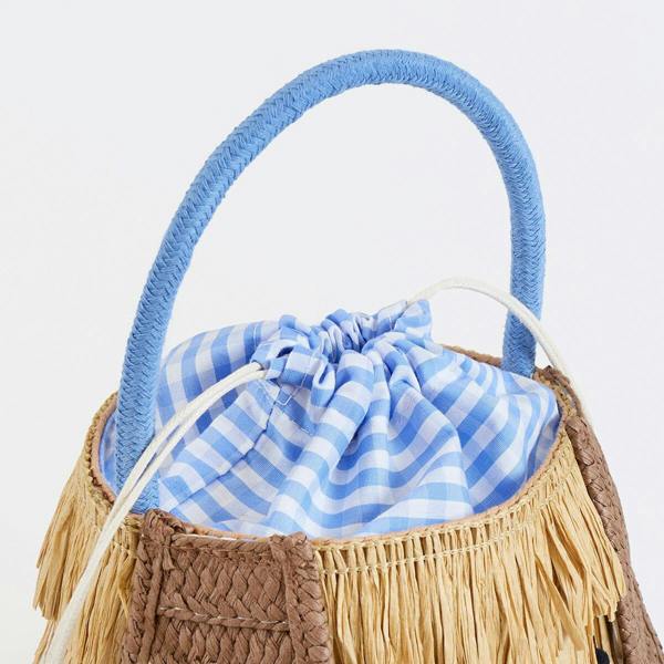 A close-up detail shot focusing on the blue and white gingham cotton drawstring closure and thick blue rope handle of the raffia puppy basket bag.