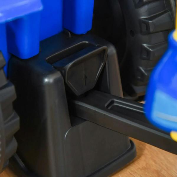 Black foot pedal and step area on a blue toddler tractor ride-on walker