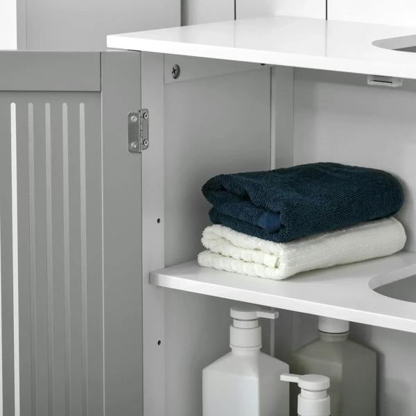Open grey under-sink cabinet showing shelves with folded towels and bottles.