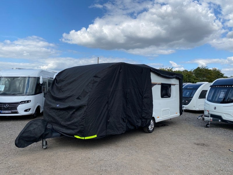 An image of the Breathable Waterproof 4Ply Caravan Cover with Free Hitch Cover Black from OLPRO with the side slightly zipped open.