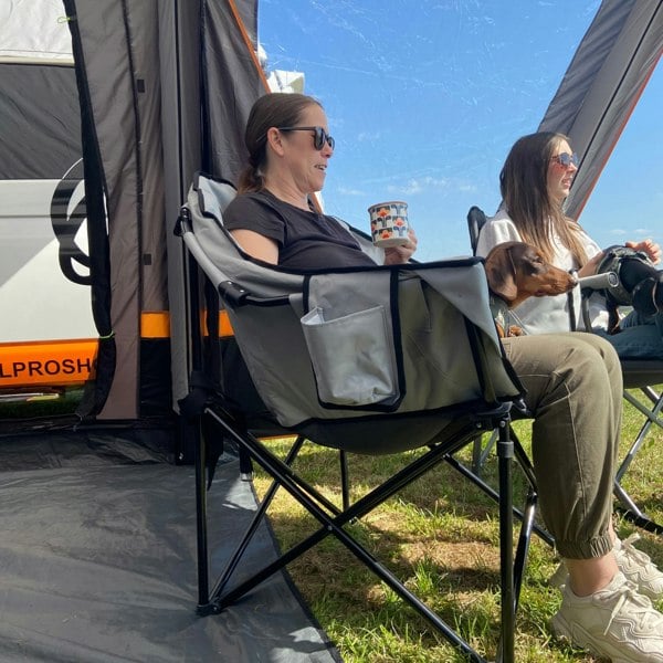 An adult sat in a Olympus XL Camping Chair from OLPRO in a campervan awning.