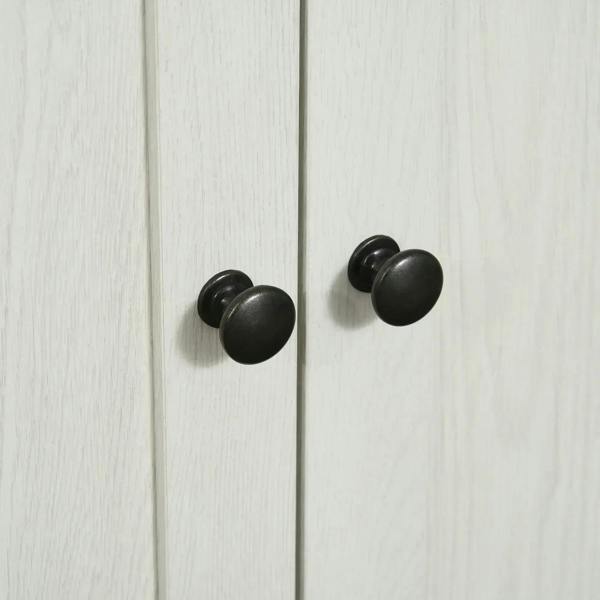 White cabinet doors with two round black knobs, close-up.