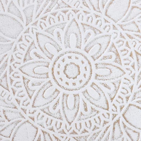 Close-up of carved floral pattern on a round white tray-style table top
