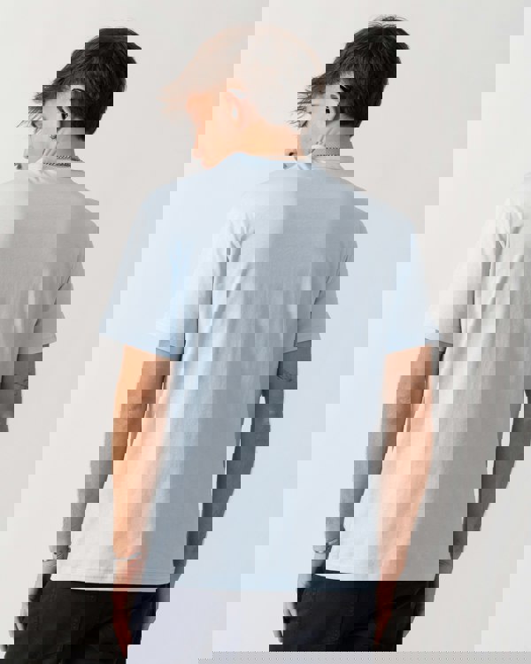 Person wearing a light blue t-shirt on a plain background