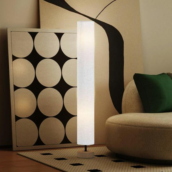 Grey linen floor lamp with glowing shade and round wooden base on rug