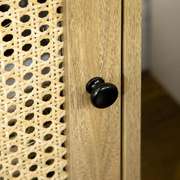 Round black knob on rattan-front cabinet door of a natural wood bedside table