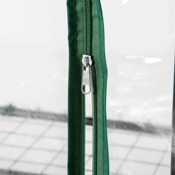Zippered door seam detail on green mini greenhouse cover, clear plastic