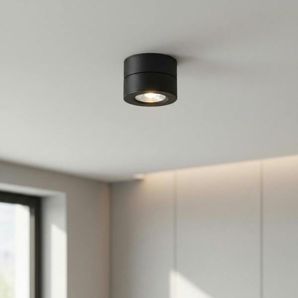 black adjustable surface mounted downlight mounted on a white ceiling
