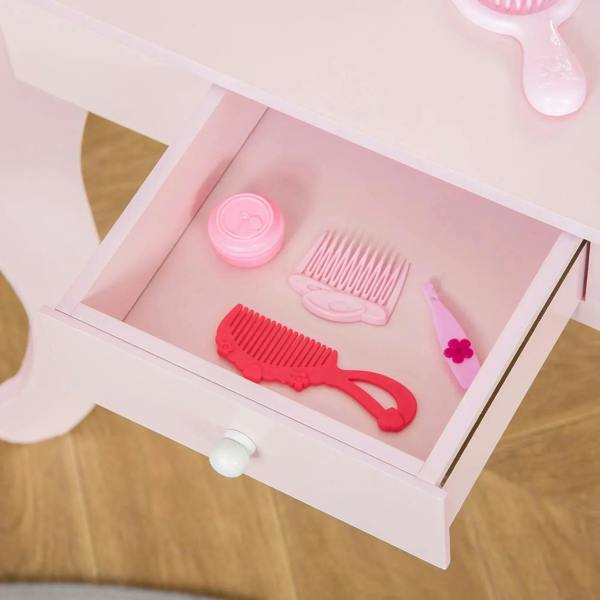 Close-up of pink vanity drawer with toy comb and brush accessories