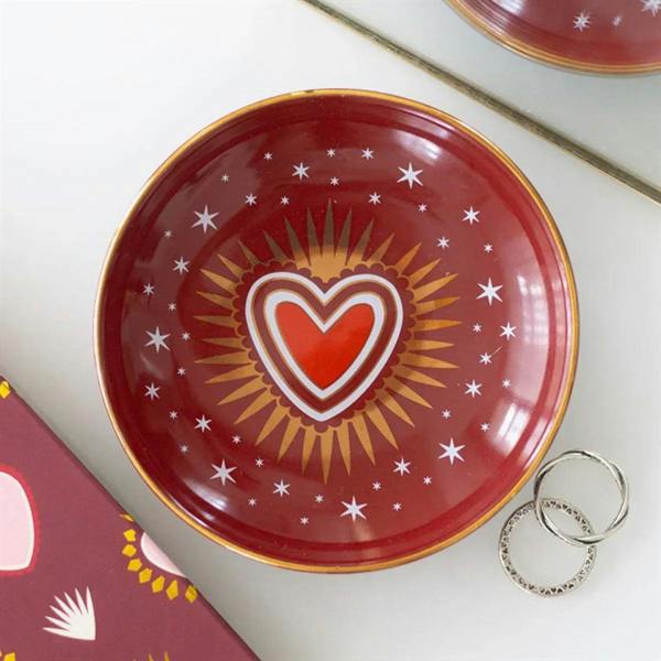 Red trinket dish with gold rim, sacred heart in white outline and sun rays