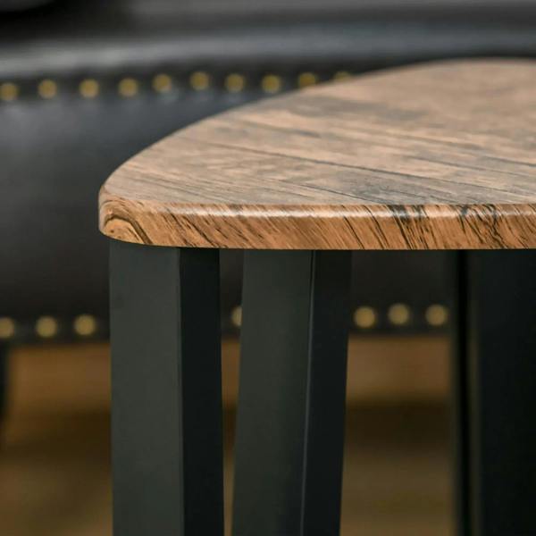 Walnut tabletop corner close-up on triangular nesting table with black metal legs