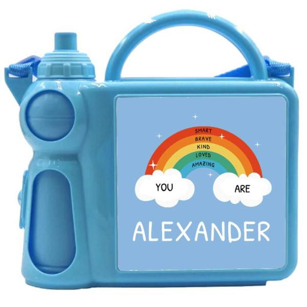 A light blue plastic kids lunch box with an attached matching water bottle, printed with a rainbow design and the name Alexander.