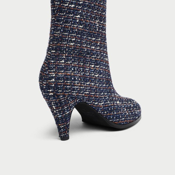 Navy blue tweed Maya ankle boot with a pattern of small white and brown dots on a light gray background heel close-up