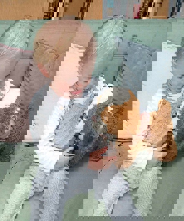 Little boy playing with Peanut Pup Pull Along toy 