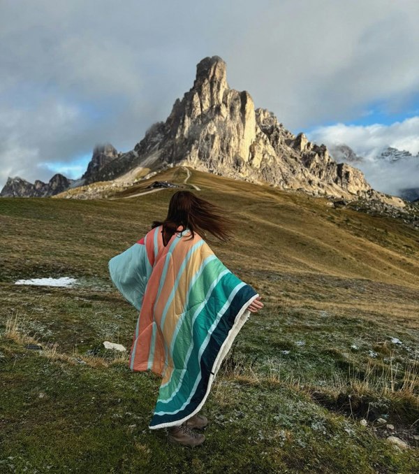 Woman wearing a Tonal Tree Tops Blanko at the foot of a mountain range