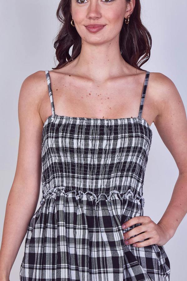 Woman wearing a black and white plaid dress against a plain background