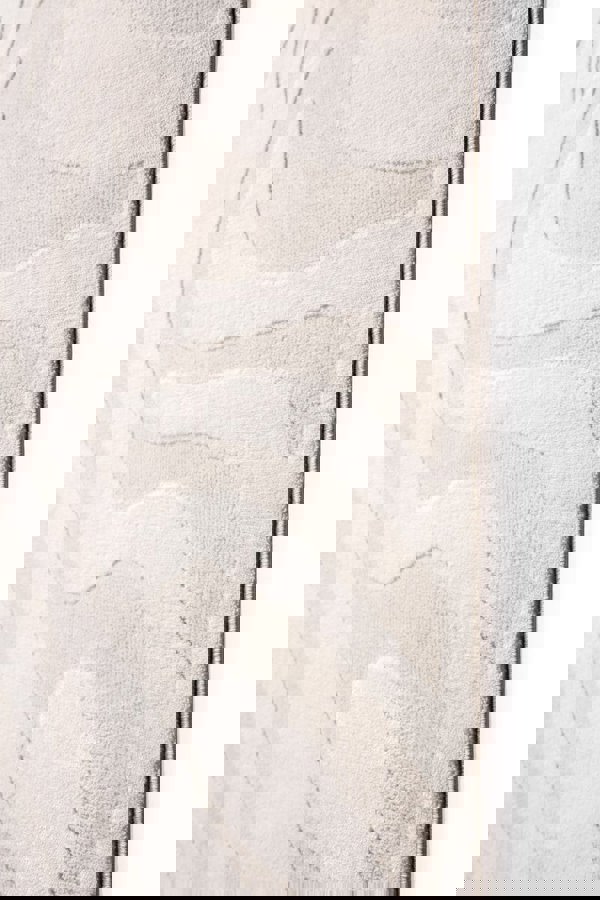 Abstract geometric rug in soft cream tones, showcasing textured patterns and modern design elements.