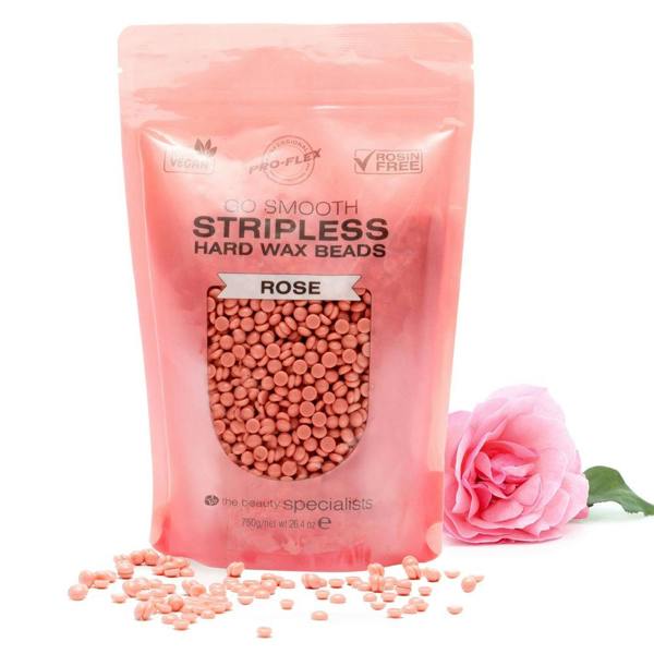 A 750g pink pouch of Rio Rose Go Smooth Stripless Hard Wax Beads sits upright with pink wax beads spilling out. A rose lies beside the resealable pouch, hinting at smooth skin, all set against a white background.