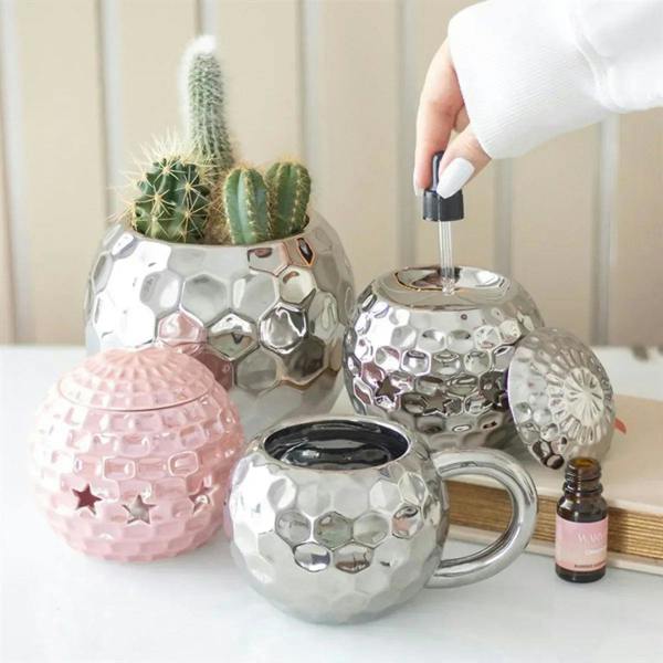 Pink disco ball-style oil burner with star cutouts and domed lid