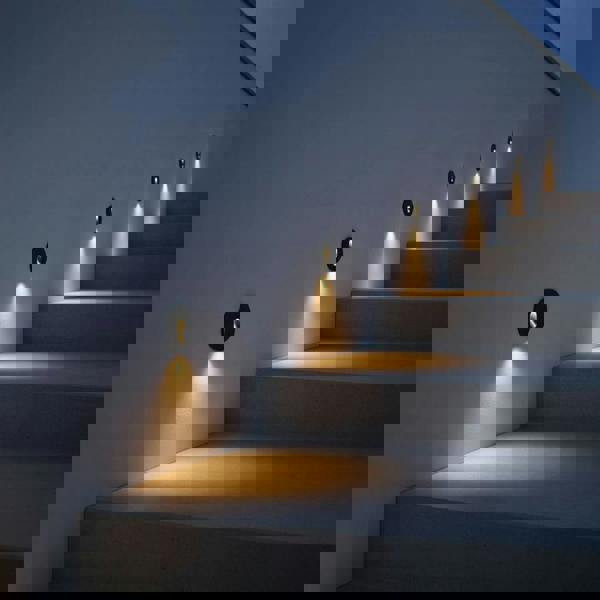 black outdoor stair step light mounted in a row going up an outside staircase