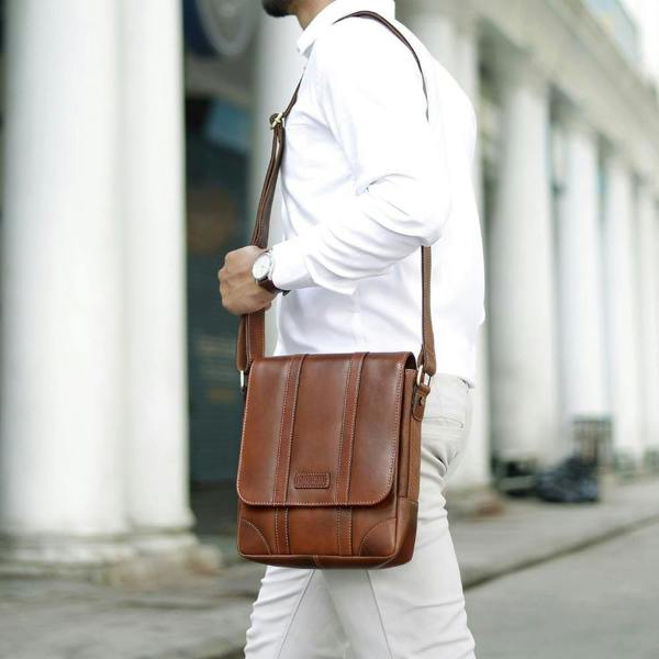 Man wearing small Brown leather messenger bag with adjustable padded strap