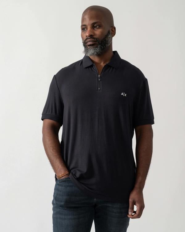 Model wearing an Armani Exchange Mens Polo Shirt in Deep Navy