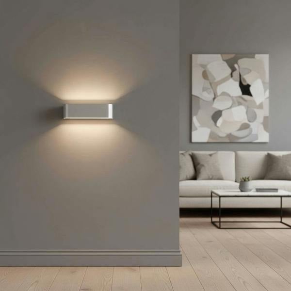 Silver up and down interior wall light illuminating a lounge area of a modern home