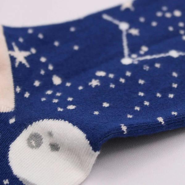 Close-up of navy bamboo sock with moon-face and star pattern