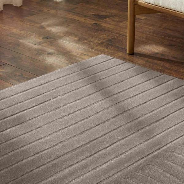 Gray rug on a wooden floor with a wooden chair partially visible.
