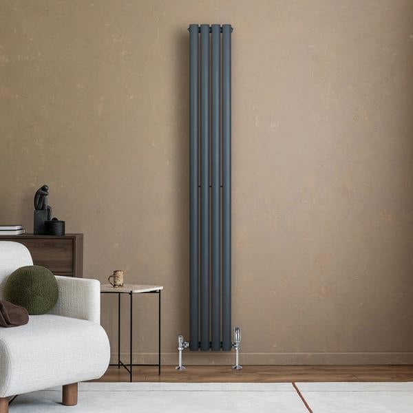 Anthracite grey oval single column radiator, 1800 x 240mm, sleek design against a textured beige wall, modern home decor setting